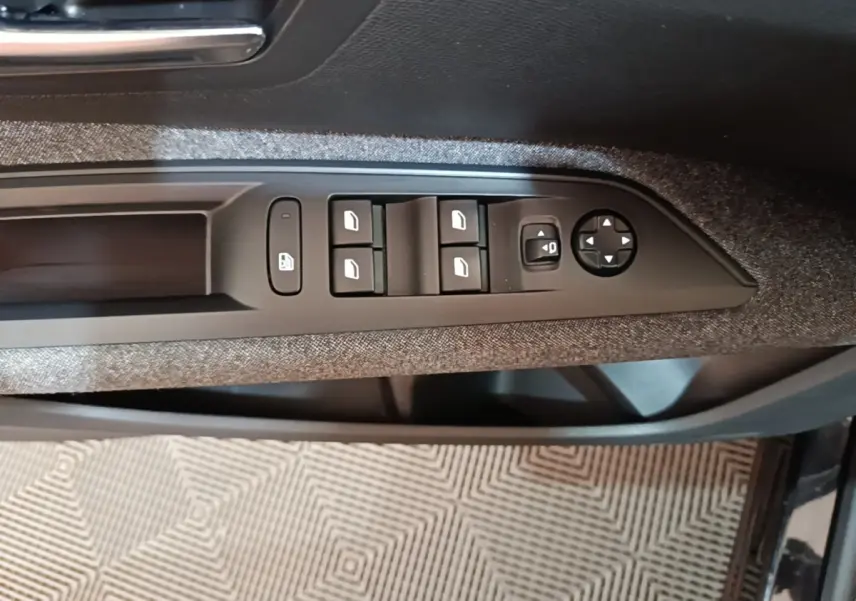 Commande des vitres et réglage des rétroviseurs sur la porte côté conducteur d’un Peugeot 5008 noir 2018.