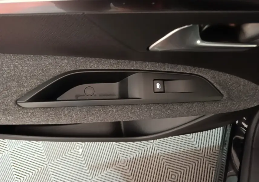 Détail de la poignée intérieure côté conducteur du Peugeot 5008 noir, avec bouton de verrouillage des portes.