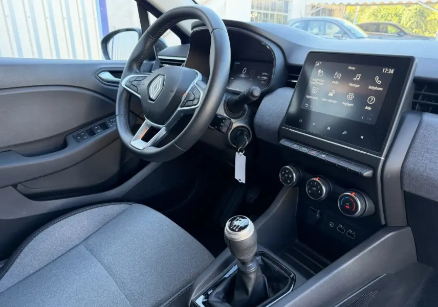 Intérieur Renault Clio Evolution TCe 90 2024 vu côté conducteur, volant cuir, écran tactile 7 pouces et levier de vitesse manuel.