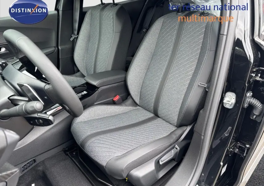 Vue intérieure côté conducteur du Peugeot 2008 Hybrid 136ch Allure 2025, sièges tissu gris et noir, portière noire ouverte.