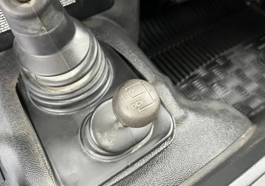 Gros plan sur le levier de blocage de différentiel du Land Rover Defender 90 Hard Top 2004, intérieur noir.