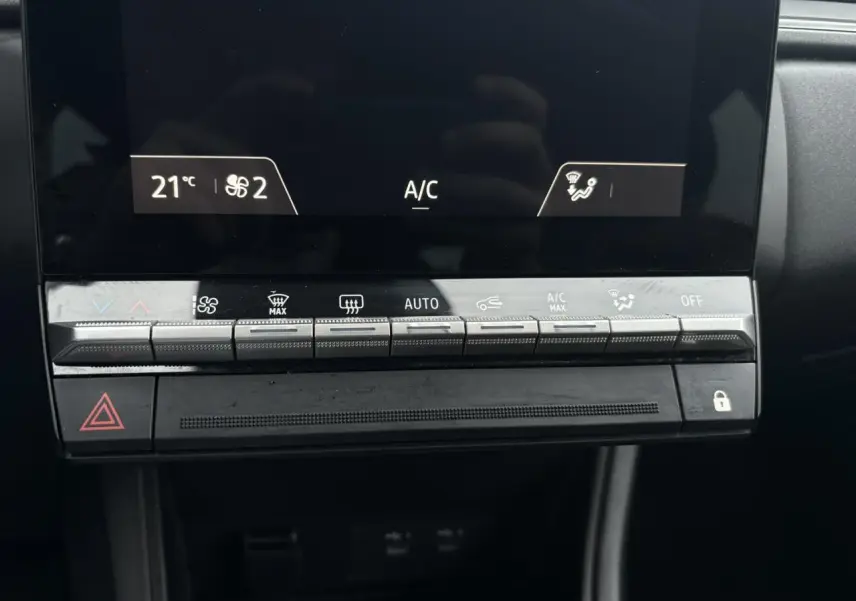 Gros plan sur la console centrale du Renault Captur 2025, boutons de climatisation automatique et écran tactile noir.