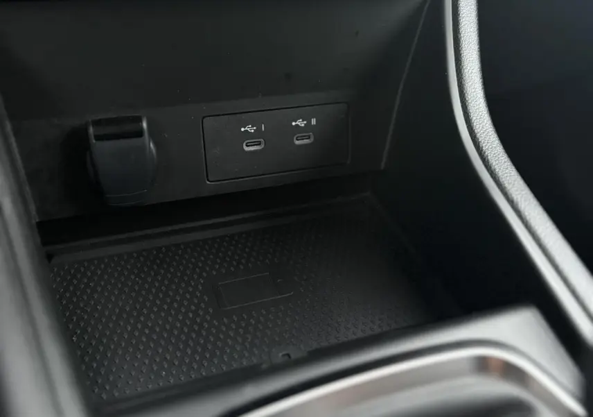 Gros plan sur la console centrale noire du Renault Captur 2025, montrant les ports USB-C doubles et un espace de charge sans fil.