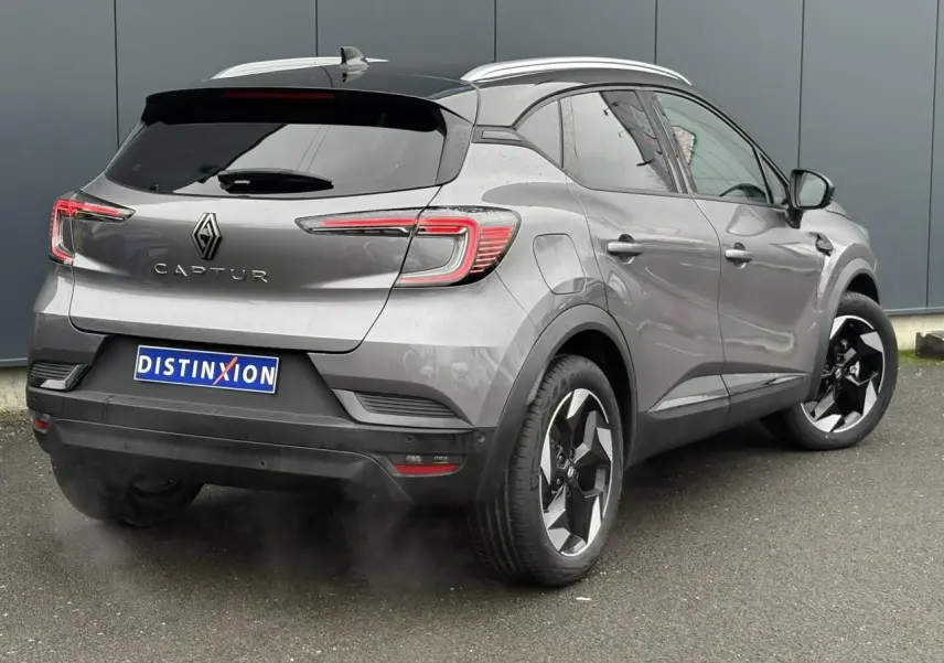 Vue 3/4 arrière droite du Renault Captur 2025 gris Cassiopée avec toit noir et jantes alu diamantées noires.