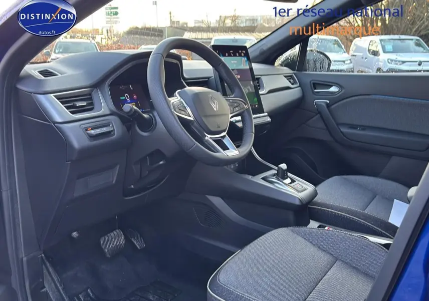Intérieur avant droit du Renault Captur bleu iron, volant multifonction et écran tactile vertical visible.