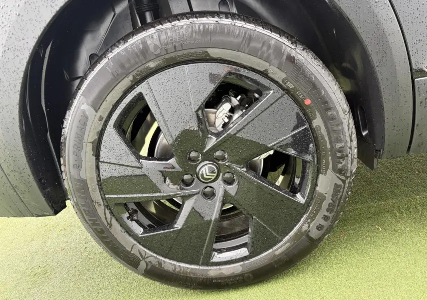 Gros plan sur la jante alliage noire 19'' Zircone d'un Citroën C5 Aircross noir métal, avec pneus Michelin mouillés.