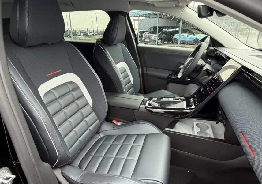 Vue intérieure côté conducteur du Citroën C5 Aircross noir métal, sièges bi-matière avec surpiqûres blanches et détails rouges.