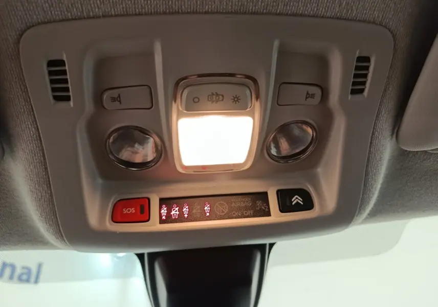 Vue en gros plan du plafonnier intérieur avec éclairage et boutons de commande de la Citroën C3 blanche 2020.
