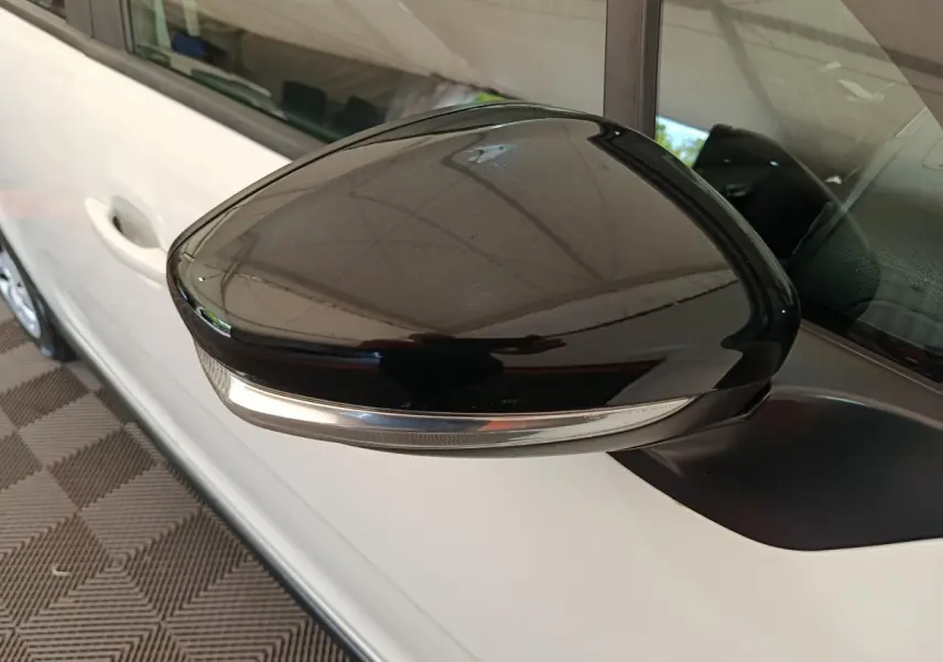 Rétroviseur noir brillant côté conducteur d'une Citroën C3 blanche 2020, avec clignotant intégré.