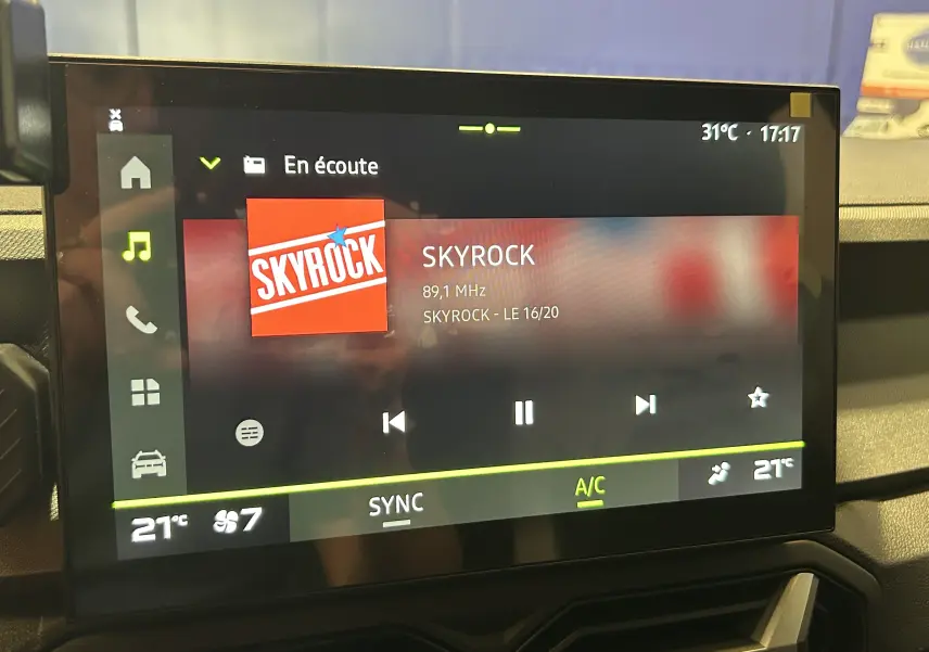 Écran tactile central du Dacia Bigster 2026 affichant la radio Skyrock, avec commandes climatisation et interface moderne.