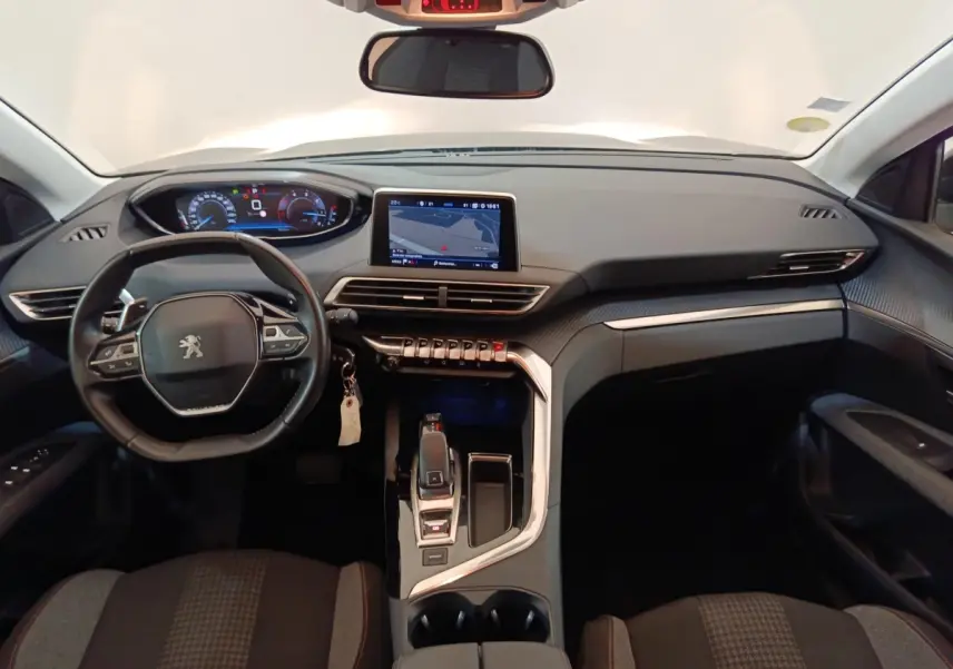 Vue intérieure avant du tableau de bord et volant cuir noir du Peugeot 5008 avec écran tactile central et commandes modernes.