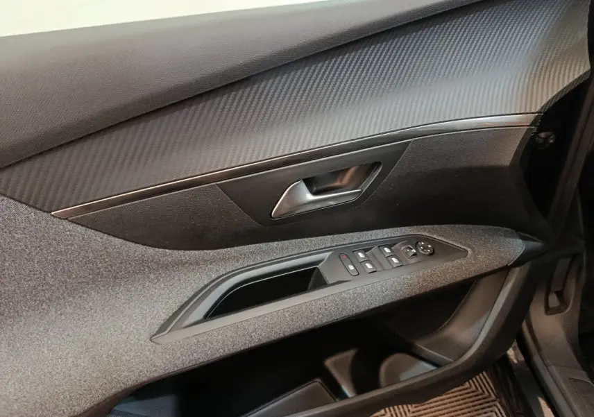 Vue rapprochée de la porte avant droite du Peugeot 5008 noir, avec commandes électriques et finition tissu/gris.