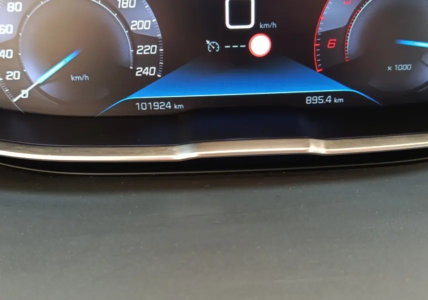 Gros plan sur le tableau de bord numérique du Peugeot 5008 noir, affichant la vitesse et le compteur kilométrique.
