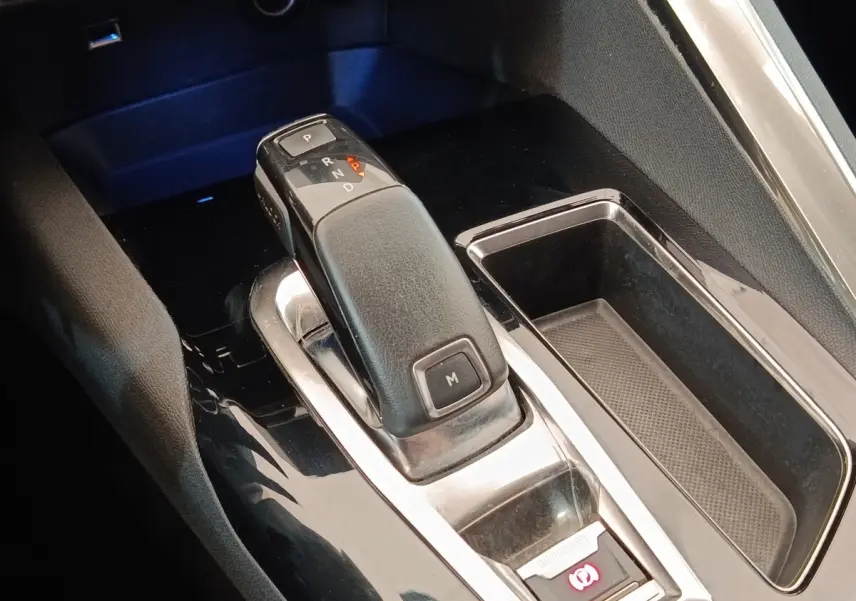 Gros plan sur la commande de boîte automatique noire et chrome du Peugeot 5008 2020, avec rangement latéral visible.