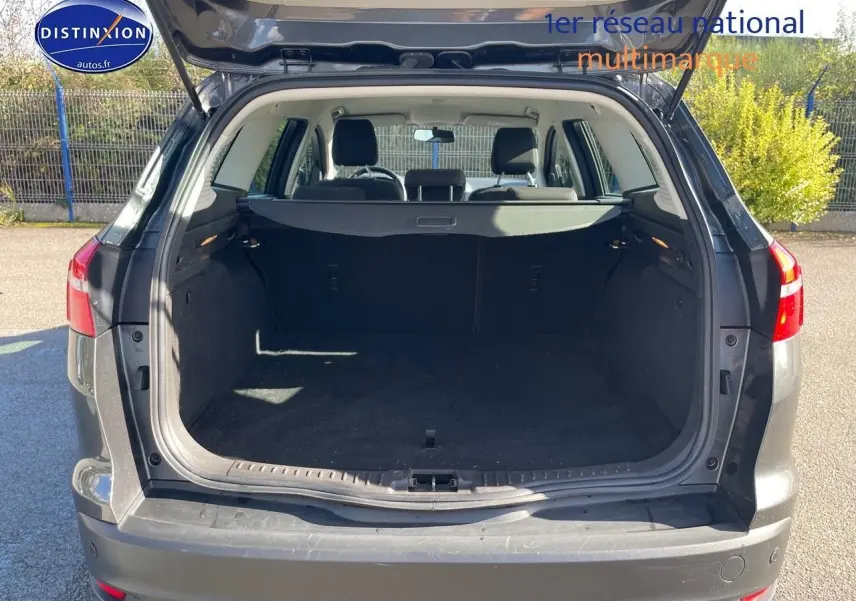 Vue arrière ouverte sur le coffre spacieux d'une Ford Focus SW 2018 gris magnetic metal, avec intérieur noir visible.