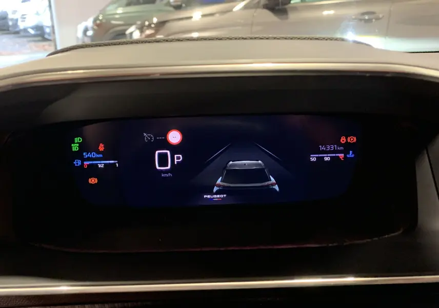 Affichage numérique du tableau de bord du Peugeot 2008 gris, montrant la voiture en position stationnaire et les indicateurs de vitesse et kilométrage.