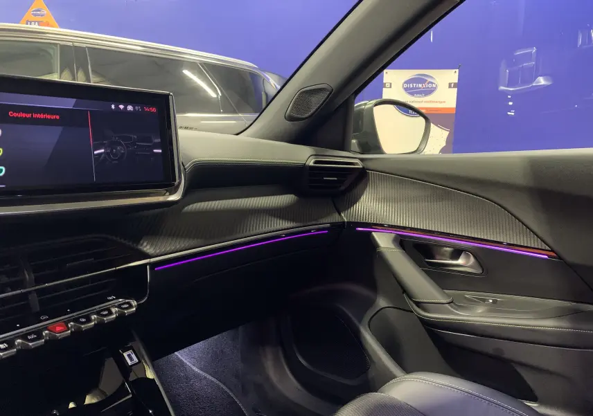 Intérieur côté passager du Peugeot 2008 gris 2023, avec éclairage d'ambiance violet et tableau de bord moderne.