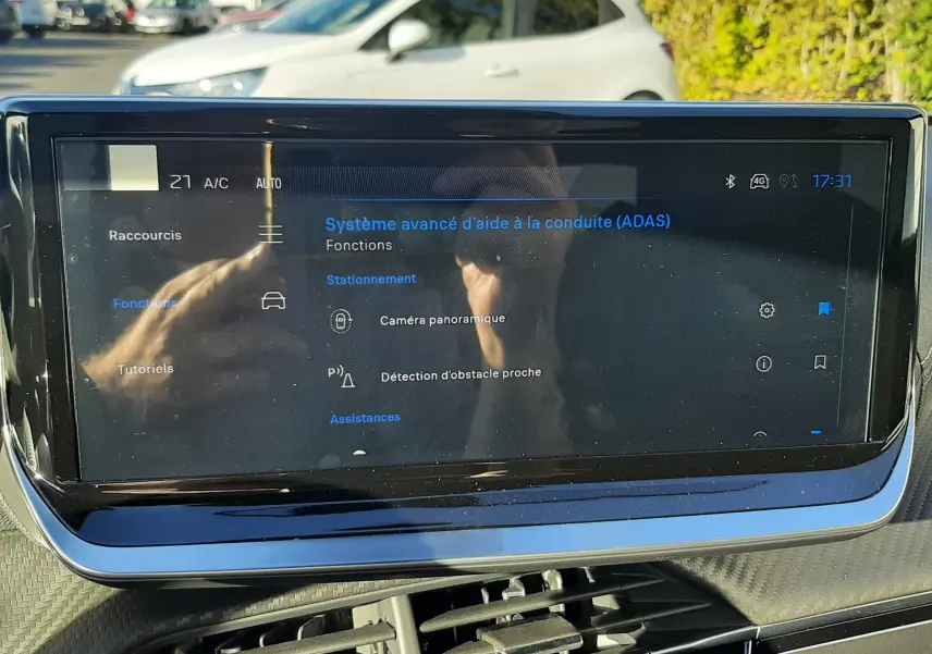 Écran tactile du système d'aide à la conduite affichant les fonctions caméra panoramique et détection d'obstacle sur Peugeot 2008 hybride.