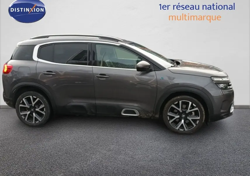 Vue de profil côté gauche d'un Citroën C5 Aircross hybride rechargeable 2022 gris platinium avec jantes alliage distinctives.