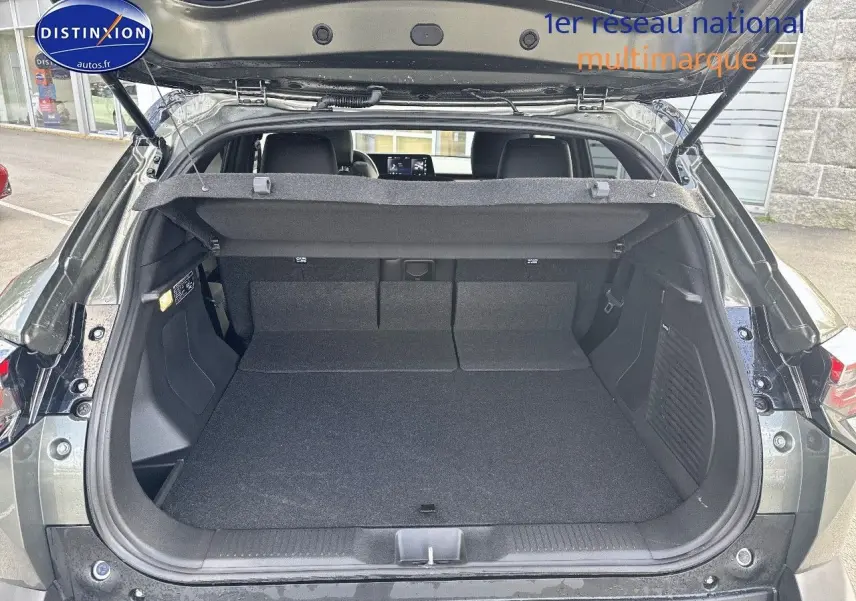 Coffre ouvert vu de l'arrière d'un Suzuki Vitara 2026 vert Land Breeze avec toit noir, intérieur spacieux et banquette rabattue.