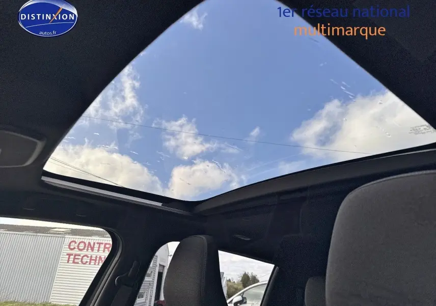 Toit panoramique en verre du Suzuki Vitara 2026 vu de l'intérieur, ciel bleu visible à travers.