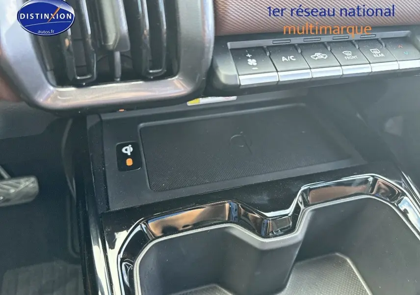 Vue rapprochée de la console centrale du Suzuki Vitara 2026 avec chargeur sans fil et commandes climatisation.