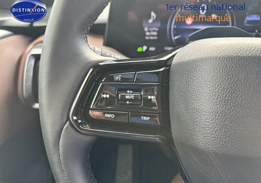 Gros plan sur les commandes du volant noir du Suzuki Vitara 2026, avec boutons multifonctions et affichage numérique en arrière-plan.