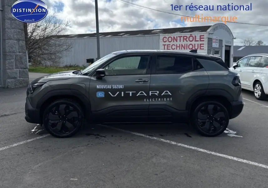 Profil droit du Suzuki Vitara électrique 2026 en vert Land Breeze avec toit noir et jantes noires.
