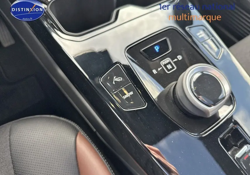 Gros plan sur la console centrale noire brillante du Suzuki Vitara 2026 avec molette de boîte auto et bouton mode Snow.