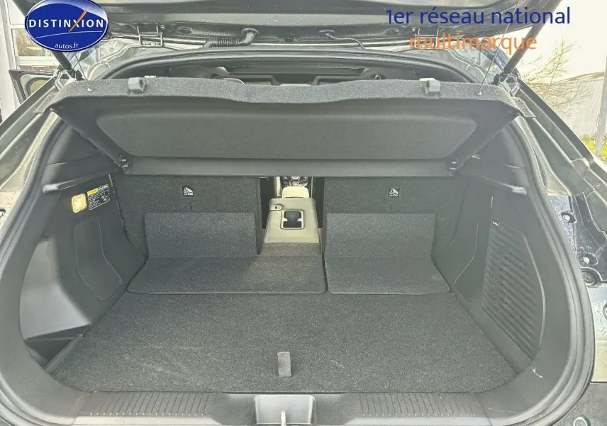 Coffre ouvert du Suzuki Vitara 2026 vert Land Breeze avec toit noir, vue arrière montrant banquette rabattue et espace de chargement.