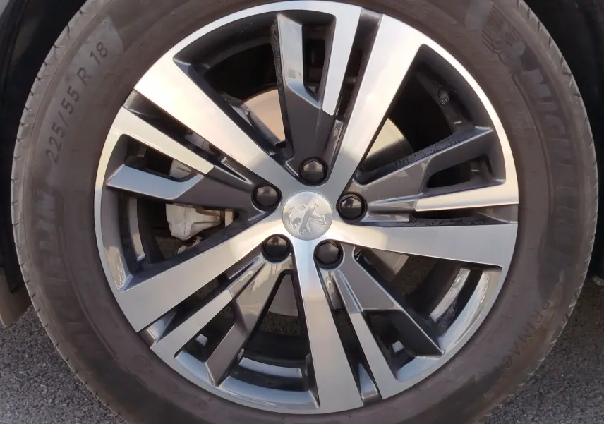 Gros plan sur la jante bi-ton noire et argent de 18 pouces d’un Peugeot 3008 Gris Platinium 2023.