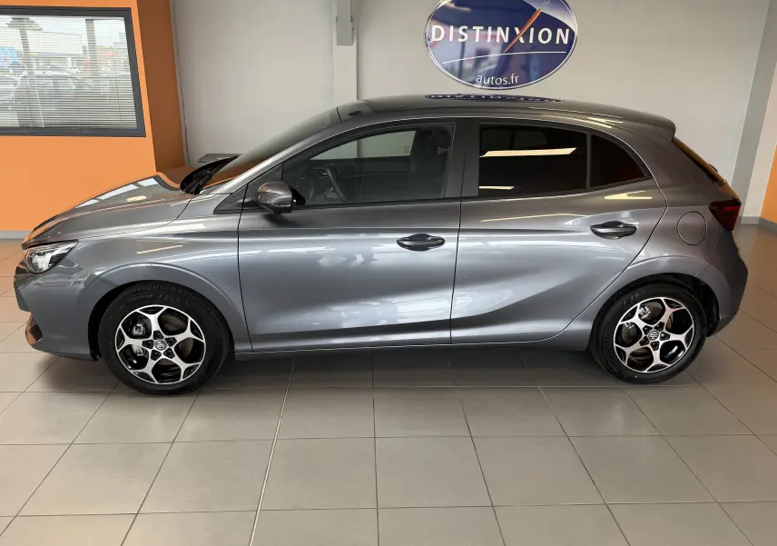 Vue latérale droite d'une MG3 hybride gris Hampstead avec jantes alliage et vitres surteintées en intérieur showroom.