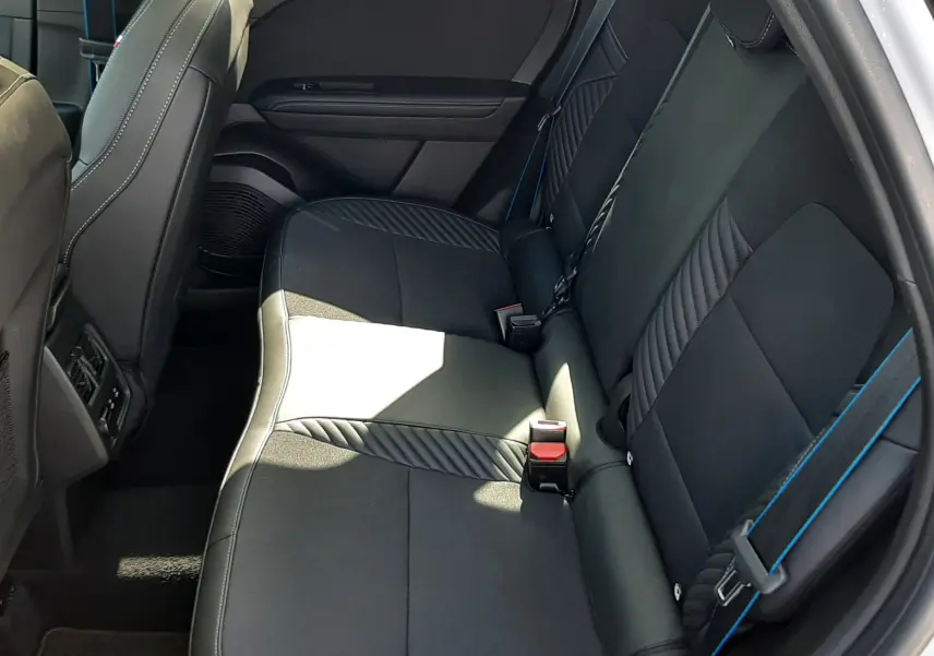 Vue intérieure côté droit des sièges arrière noirs avec surpiqûres bleues du Renault Symbioz E-Tech Full Hybrid 2025.