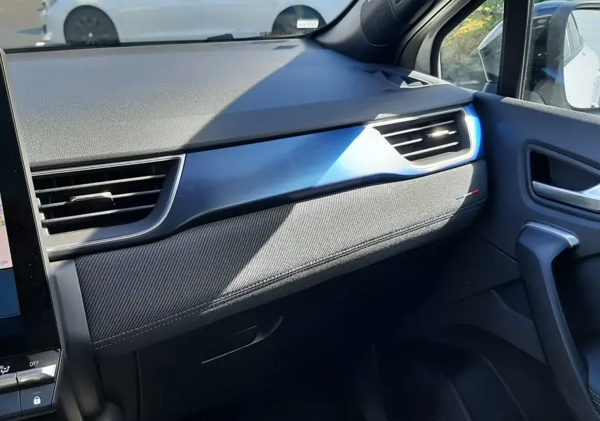 Vue intérieure côté passager du tableau de bord du Renault Symbioz gris Rafale, avec détails bleus et tissu noir.