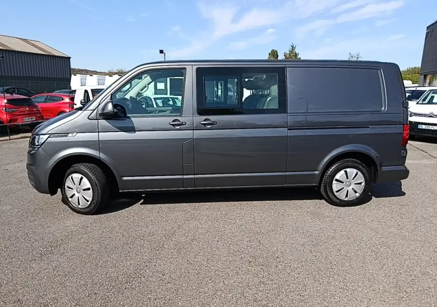 Vue latérale droite d’un Volkswagen Transporter gris foncé 2022, fourgon utilitaire avec vitres avant et portes coulissantes.