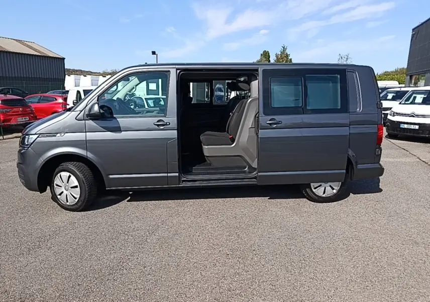 Vue latérale droite d’un Volkswagen Transporter gris foncé 2022 avec porte coulissante ouverte montrant les sièges arrière.