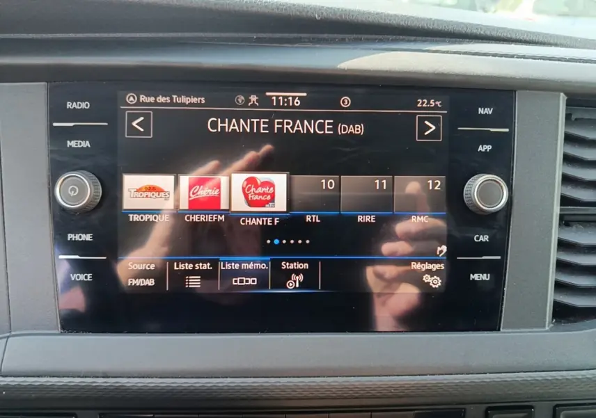 Écran tactile central du tableau de bord du Volkswagen Transporter gris foncé, affichant la radio numérique.