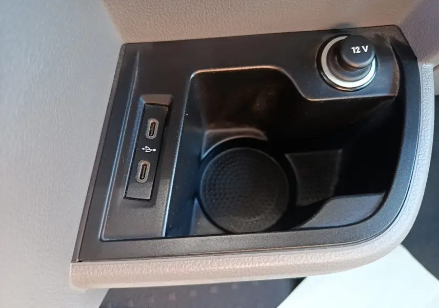 Prise 12V et deux ports USB-C dans le compartiment de rangement intérieur du Volkswagen Transporter gris foncé.