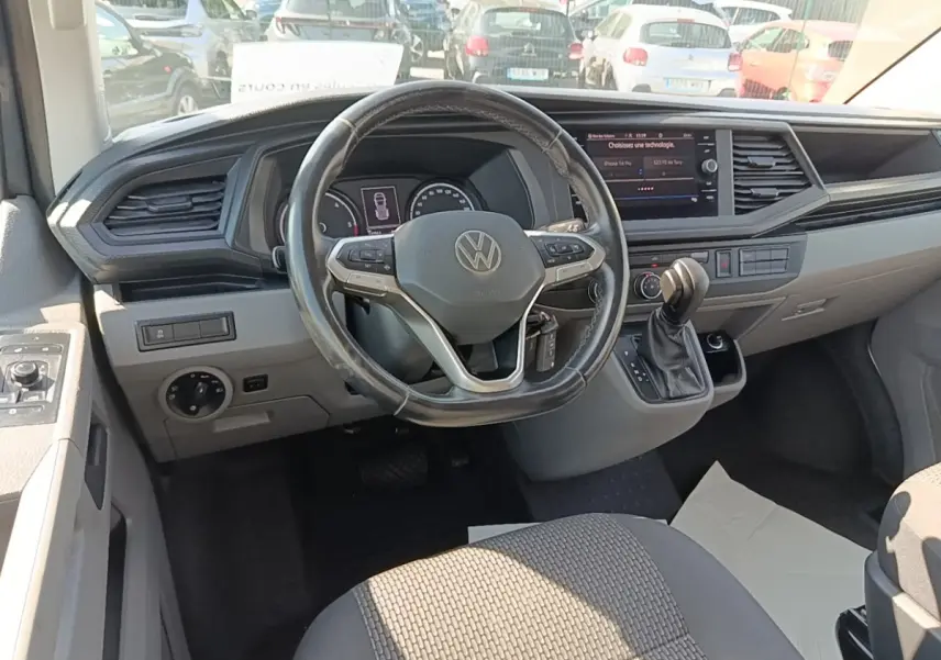 Vue intérieure du tableau de bord et volant cuir multifonctions d’un Volkswagen Transporter gris foncé de 2022.
