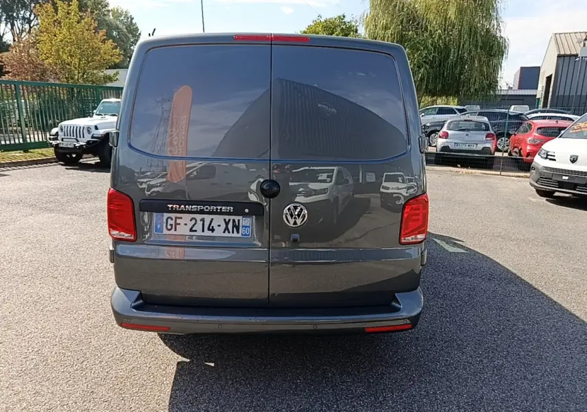Vue arrière d’un Volkswagen Transporter gris foncé 2022 avec portes battantes et feux rouges visibles.