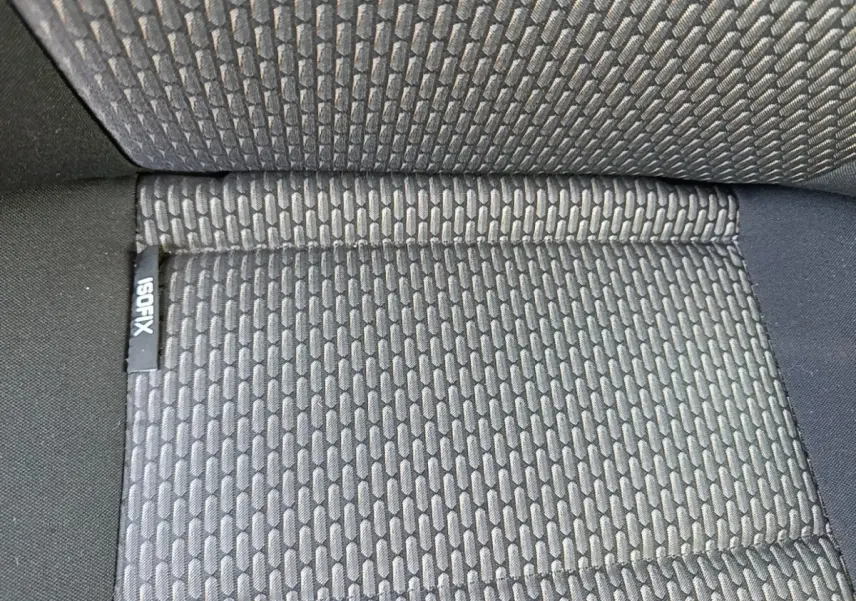 Gros plan sur le tissu gris foncé du siège arrière du Volkswagen Transporter 2022 avec étiquette ISOFIX visible.