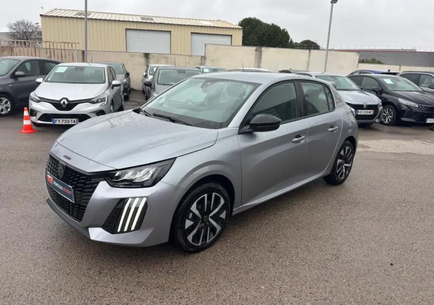 Peugeot 208 Hybrid gris vue 3/4 avant droit, avec feux diurnes LED verticaux et jantes 16 pouces.