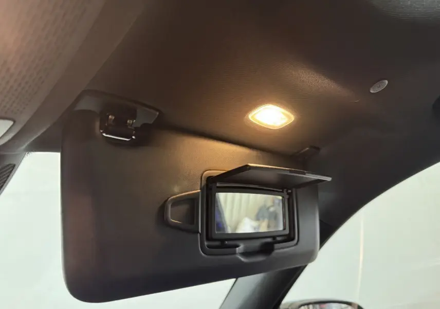 Détail intérieur du pare-soleil côté conducteur avec miroir éclairé dans le Mercedes GLB 200 d AMG Line noir.