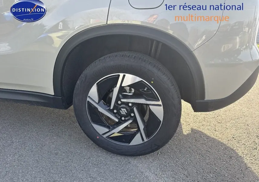 Gros plan sur la roue arrière droite d’un Suzuki Vitara 2026 couleur Savanna Ivory avec jante alu noire et argent.