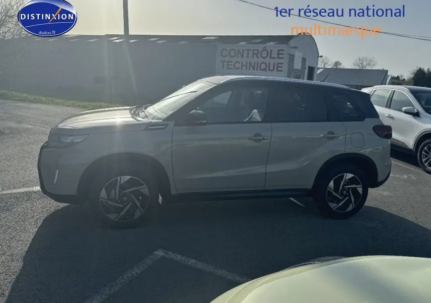Suzuki Vitara 1.4 Boosterjet Hybrid 2026 vue de profil côté gauche, couleur ivoire et toit noir, jantes alu distinctives.