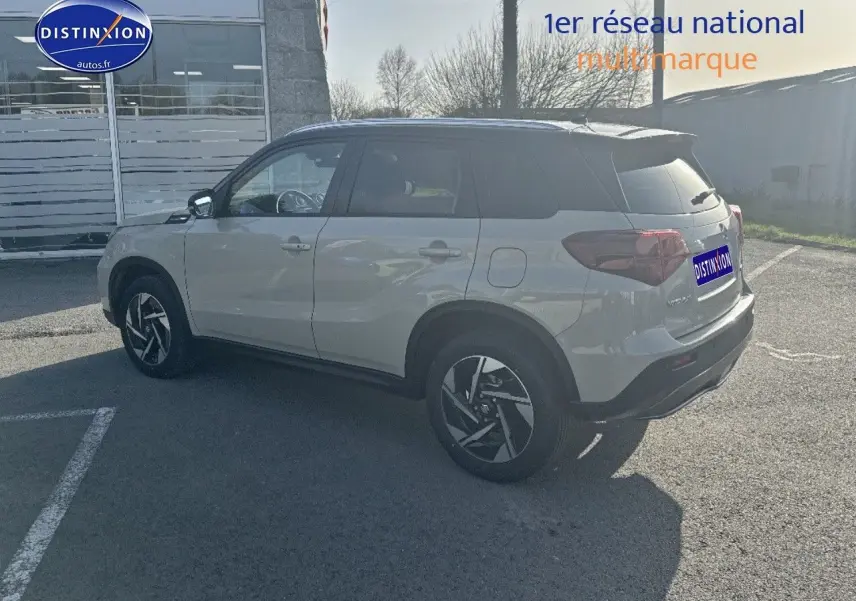 Suzuki Vitara 1.4 Boosterjet Hybrid 2026 vue 3/4 arrière côté gauche, couleur ivoire et toit noir métallisé.