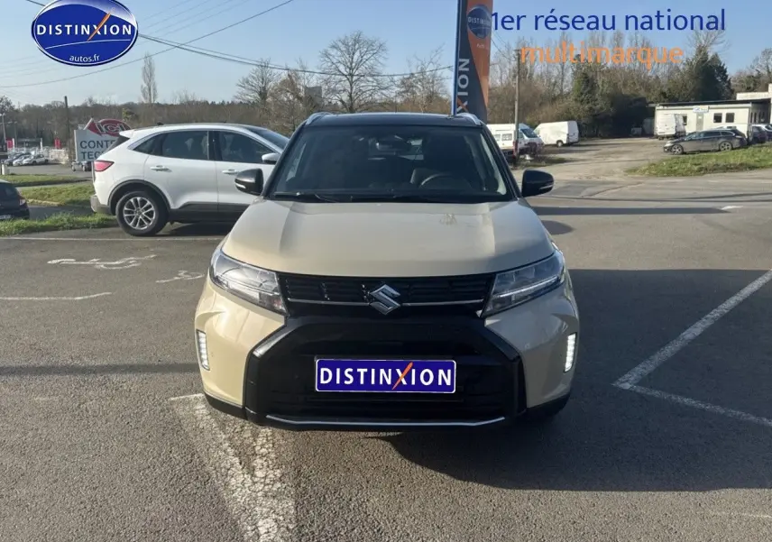 Suzuki Vitara 2026 beige So'Color Savanna Ivory vue de face avec calandre noire et feux LED allumés.