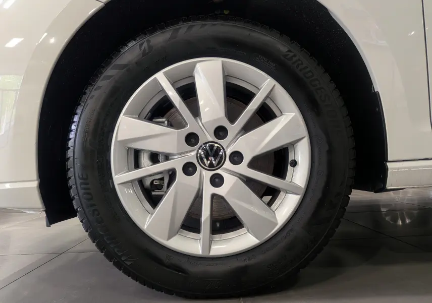 Gros plan sur la roue avant gauche blanche d’un Volkswagen Caddy 2.0 TDI 2025 avec jante alliage et pneu Bridgestone.