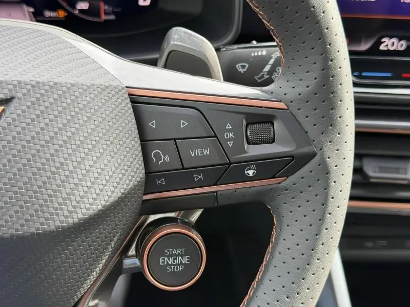 Gros plan sur le volant perforé gris avec commandes multifonctions et bouton Start Engine Stop du CUPRA Formentor bleu.