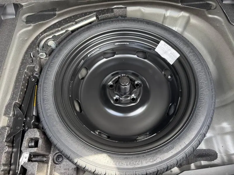 Vue rapprochée de la roue de secours noire dans le coffre d'une CUPRA Formentor bleu Fjord 2026.